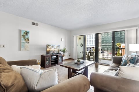 Bright & airy living room with sliding glass doors that lead to outdoor private balcony