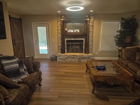 Warm and comfortable living room with cozy seating, hardwood floors, and a fireplace as the focal point. Thoughtfully arranged for relaxation and conversation, creating a welcoming space to unwind.
