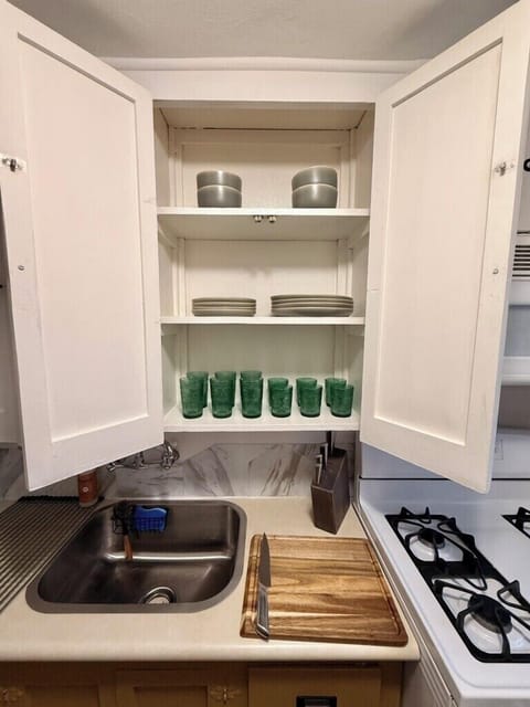 Plates and bowls for 4, sharp knives, and cutting boards. Full set of non-stick and non-toxic pots and pans.