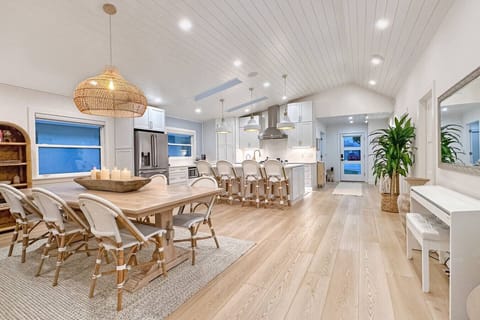 Spacious open-concept kitchen and dining space with high ceilings and coastal design