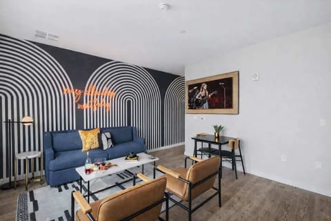 Bright open floor living space featuring a smart flat-screen TV and designer furnishings. Connects to the dining area and kitchen.