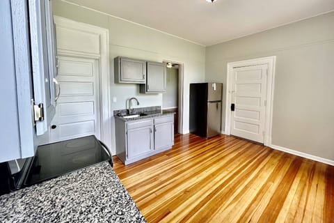 Door to the right of the refrigerator leads out to a covered patio overlooking Barnhardt Circe Park