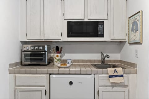 Kitchenette with microwave, toaster oven, and mini refrigerator.