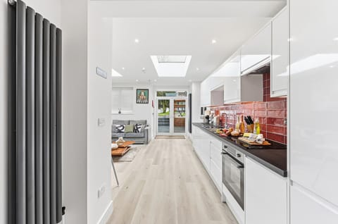The open-plan kitchen and living area features skylights, creating a bright and airy space.