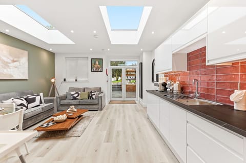 The open-plan kitchen and living area features skylights, creating a bright and airy space.