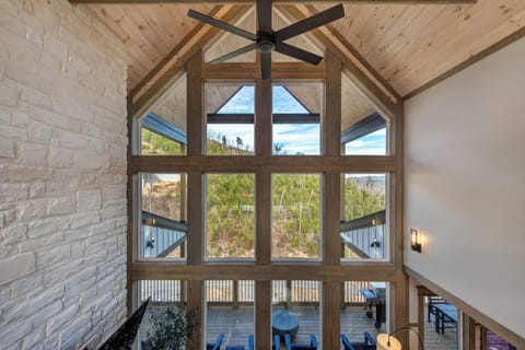 Soaring ceilings and floor-to-ceiling windows frame stunning natural views, while warm wood beams create your perfect mountain retreat.