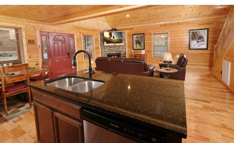 Gather around this granite kitchen island while your friends relax by the stone fireplace in this warm, inviting cabin retreat.
