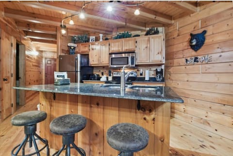Step into your rustic mountain kitchen where granite counters meet warm wood beams, creating the perfect space for morning coffee and meal prep.