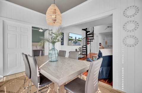 Gather around your elegant dining table under warm pendant lighting, perfect for memorable meals with loved ones in this beautifully appointed space.