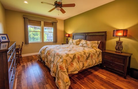 Unwind in a serene king bedroom with warm wood floors.