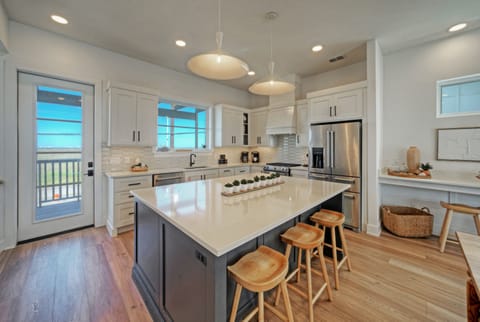 Fully equipped kitchen with large island, barstool seating, and reliable equipment.