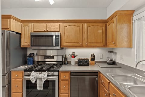 A fully-equipped chef’s kitchen featuring stainless steel appliances and ample prep space.