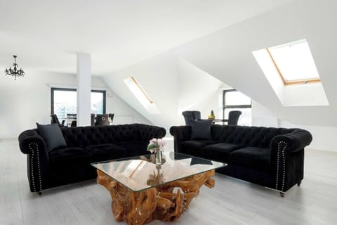 The living area features a sleek coffee table and a flat-screen television.