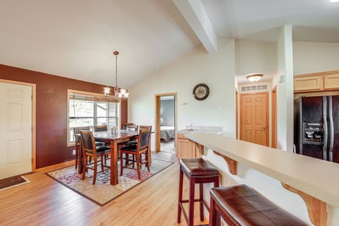 Your open-concept kitchen and dining space features warm wood finishes, modern appliances, and a breakfast bar perfect for morning coffee or casual meals.