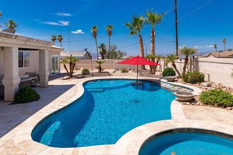 Refreshing pool and attached spa surrounded by palm trees — your own desert retreat.