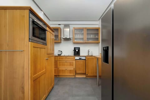 Kitchenette view with cabinets, countertop, and storage.