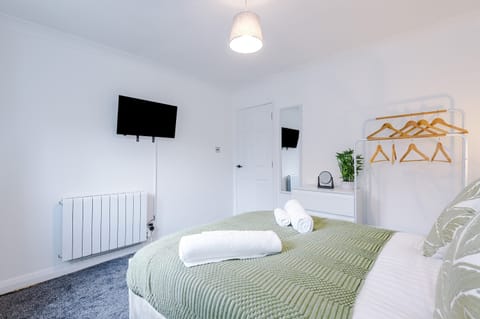 Bedroom: Modern retreat with stylish decor, plush bedding, and a wall-mounted TV for ultimate comfort!