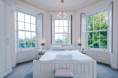 Dreamy Bedroom: Enchanting bay windows bring nature indoors, perfect for a peaceful retreat!