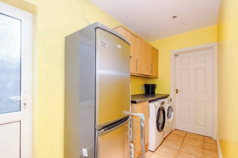 Laundry Room: Bright and functional space with modern appliances and cheerful yellow walls!