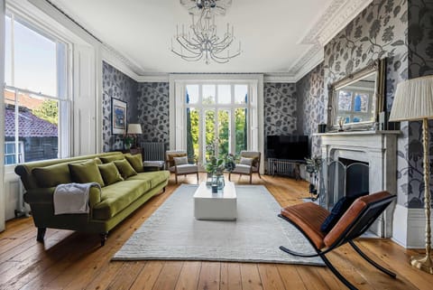 Living Room: Bright and stylish space adorned with floral wallpaper and vibrant green furniture!