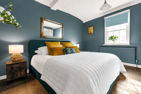 Bedroom Retreat: Moody teal walls and plush white bedding for a stylish night's sleep!