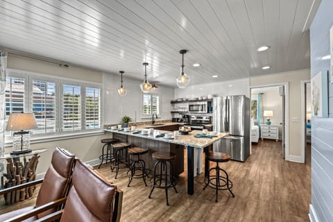 The living area leads into the clean, modern kitchen with sleek appliances.