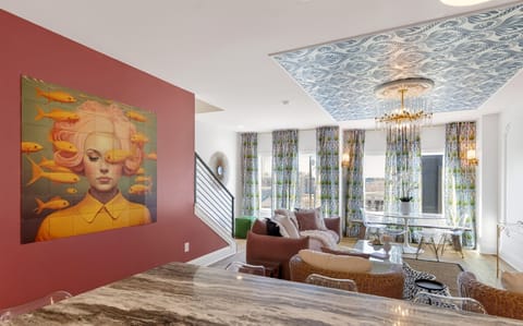 Stylish living room with statement ceiling, chandelier, and lounge seating.