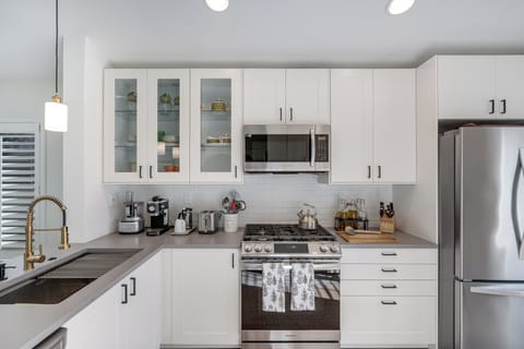 Your sleek kitchen features premium appliances, gleaming countertops, and thoughtful touches that make cooking a joy during your stay.