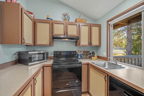 Your fully equipped kitchen features everything for cooking meals, from the spacious countertops to modern appliances, all with tree-lined views.