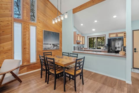 Gather around your spacious dining table in this bright, modern kitchen where exposed beams and warm wood create the perfect atmosphere for memorable meals.