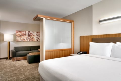 Unwind in crisp linens with a cozy lounge corner nearby.