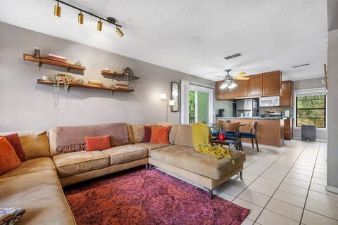 Living room with live edge shelving and track lighting which adds great style in this space.  You see most of the downstairs from this photo.