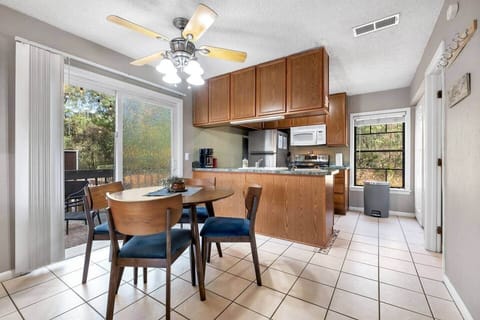 Round walnut dining table seats 4 with additional seats found on the deck outside.