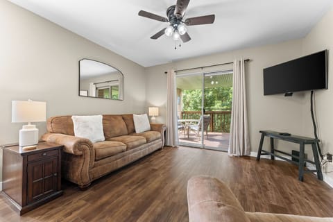 Bright living area with cozy furnishings and direct access to the covered balcony—perfect for morning coffee or evening relaxation.