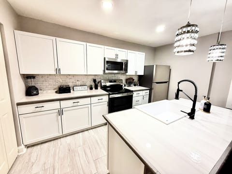 Sleek countertops, farmhouse sink, and modern fixtures make this kitchen both functional and beautiful for extended stays.