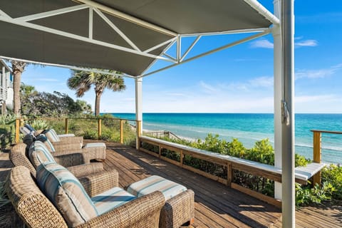 Sink into plush wicker seating beneath your private shade sail and soak up endless turquoise ocean views from this stunning beachfront deck.