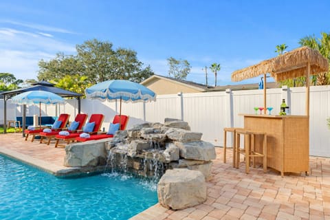 Swim up to the waterfall and unwind at the backyard tiki bar!