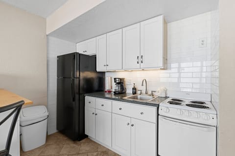 Prepare meals with ease in this bright, fully equipped kitchenette featuring full-size appliances, ample cabinet space, and modern finishes. A convenient addition to your relaxing beach stay vacation rental by the ocean.