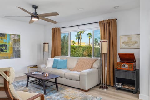 Abstract artwork, warm wood accents, and a soft area rug add character and comfort to this thoughtfully designed interior.