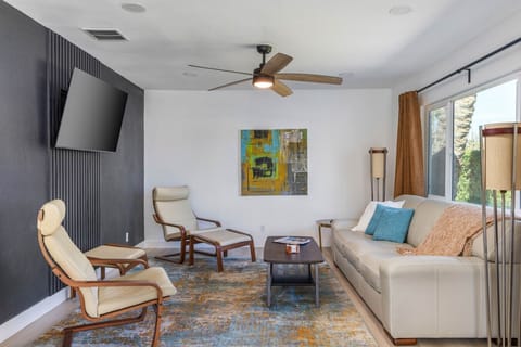 Comfortable seating, a large wall-mounted TV, and stylish accent wall create the perfect setting for relaxing or entertaining.
