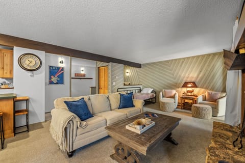 Unwind in your cozy living space featuring rustic wood accents, plush seating, and warm lighting that creates the perfect mountain retreat atmosphere.