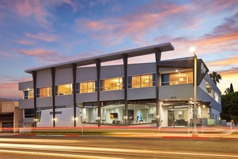 Arrive to a sleek, modern facade glowing at sunset.