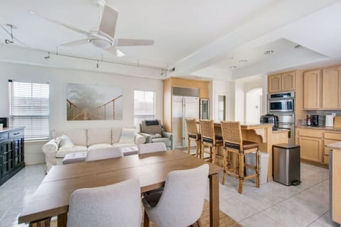 Living room connected to the kitchen with a Smart TV and dining table for four.