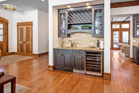 The dedicated wet bar features wine refrigerator, specialty dishwasher, sink, and glassware for effortless entertaining. Mix après-ski cocktails, pour evening wine, or prep morning mimosas, everything at hand for happy hour without leaving the living room