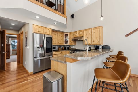 Gather around this spacious granite island where morning coffee and evening conversations flow naturally in your beautifully appointed mountain kitchen.