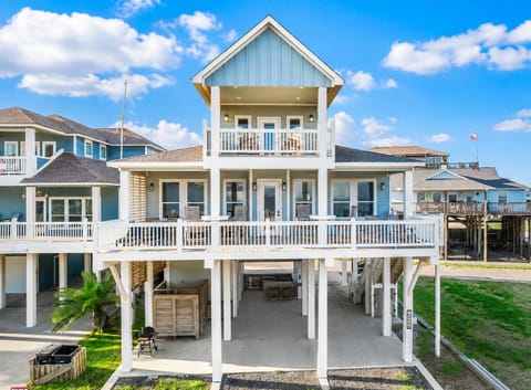Elevated Bolivar Peninsula beach house with spacious upper and lower decks, coastal exterior, covered ground-level area, and ample outdoor space near the Gulf.