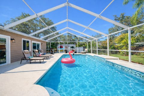 A stunning full-length view of the private screened pool with serene wooded surroundings, offering both privacy and a peaceful retreat.