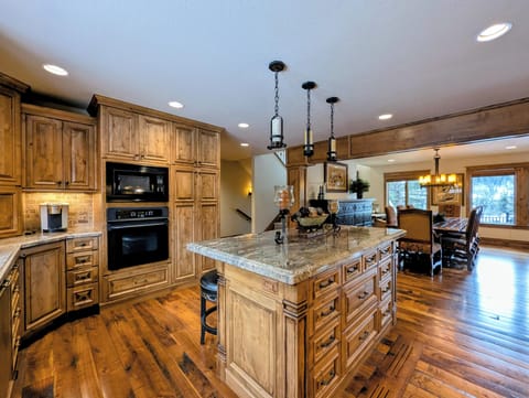 Your gourmet kitchen awaits with rich wood cabinetry, granite island, and modern appliances—perfect for creating memorable meals together.