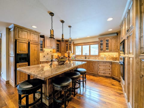 Step into your gourmet kitchen where rich wood cabinets and granite countertops create the perfect space for cooking memorable meals together.