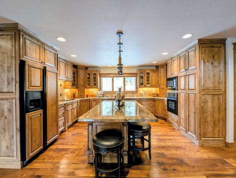 Step into your gourmet kitchen where rich wood cabinetry and granite counters invite culinary adventures. The spacious island becomes your gathering spot.
